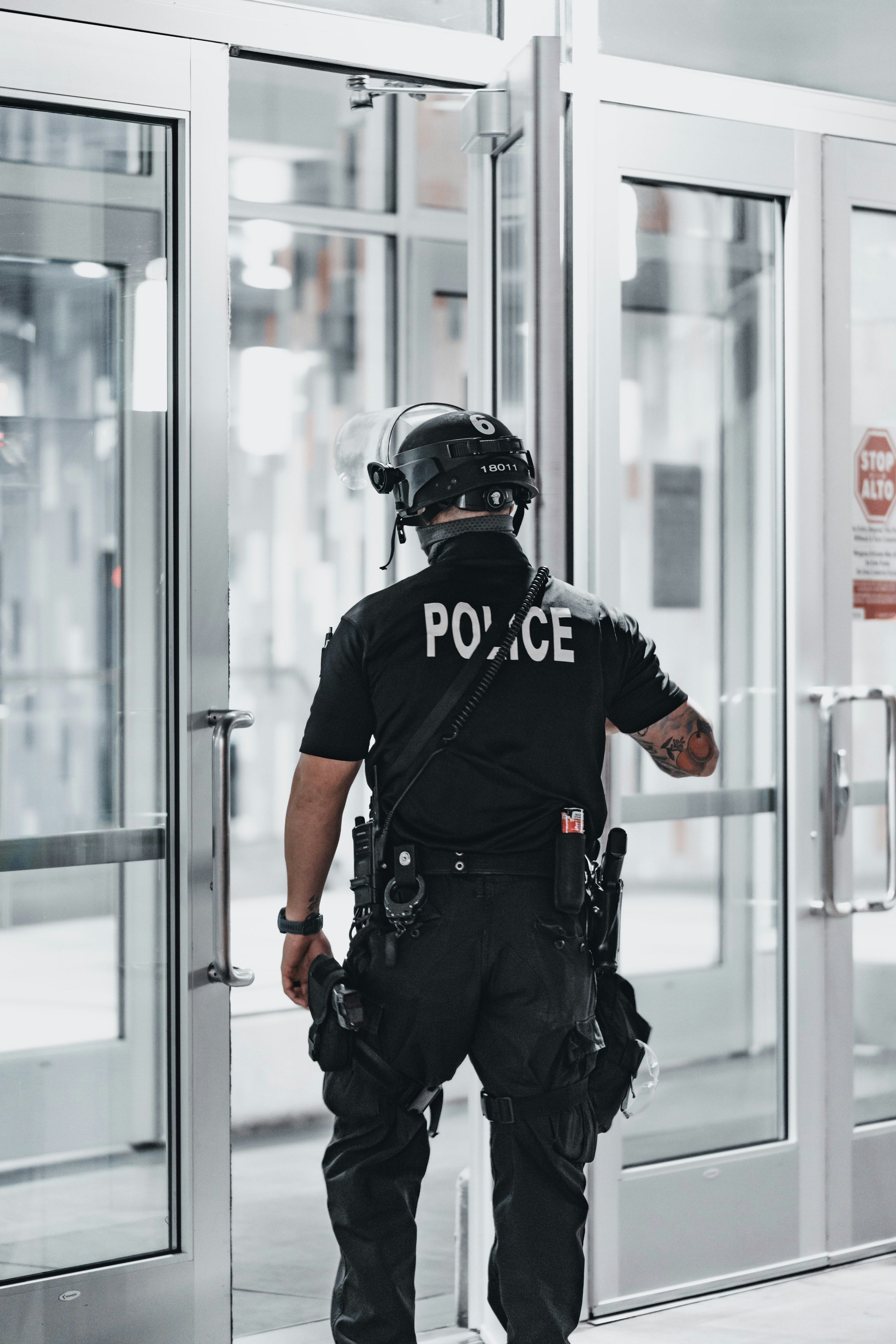 man in black helmet and black helmet standing near glass window